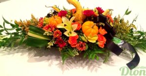 Centre de table naturel avec fleurs d'automne, feuillages et courges