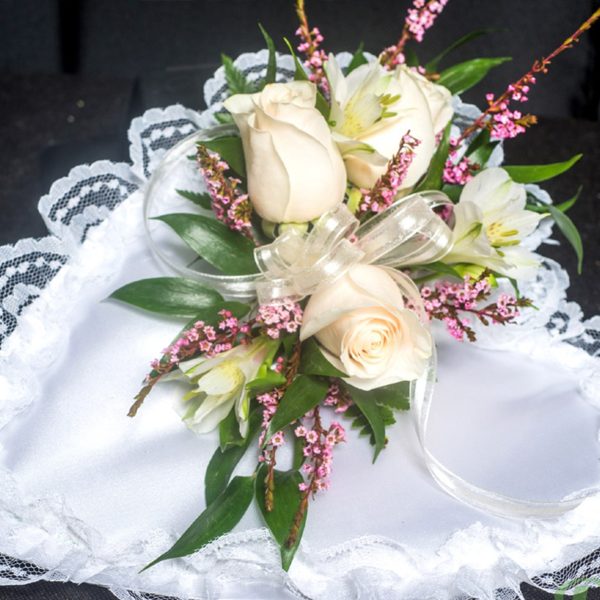 arrangement sur un coussin cœur de satin avec des fleurs coupés